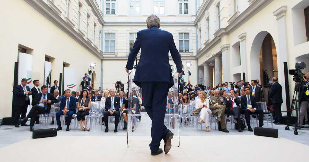 Paolo Gentiloni di spalle mentre parla al Trieste Summit